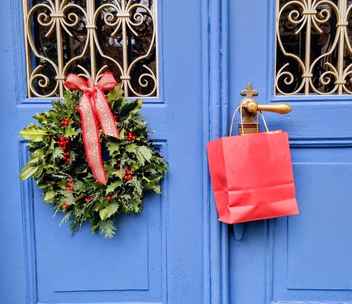 Weihnachtlich geschmückte blaue Eingangstür mit Kranz