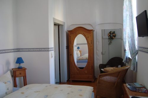 Gästezimmer mit Kleiderschrank, Sitzecke und Blumendekoration
